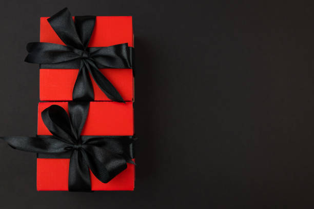 istock Top view photo of red gift boxes with black bow on isolated black background with copy space. 2187339561