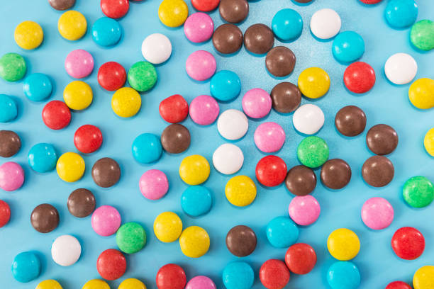 istock round colored candies on a blue background. Colored candy background, texture. 2187339670