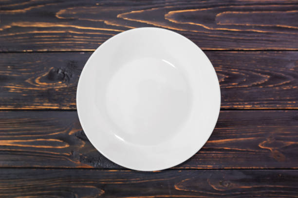 istock white empty plate on a wooden background. View from above. Flat lay. 2187339899