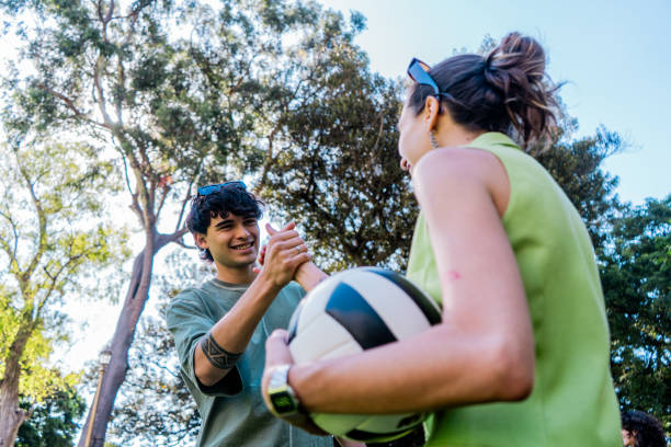 istock Young man greeting a friend at public park 2187340015