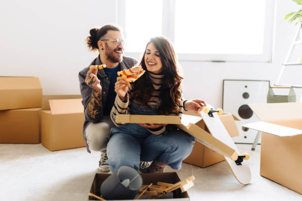 istock Young couple eating pizza in new home 2187344872