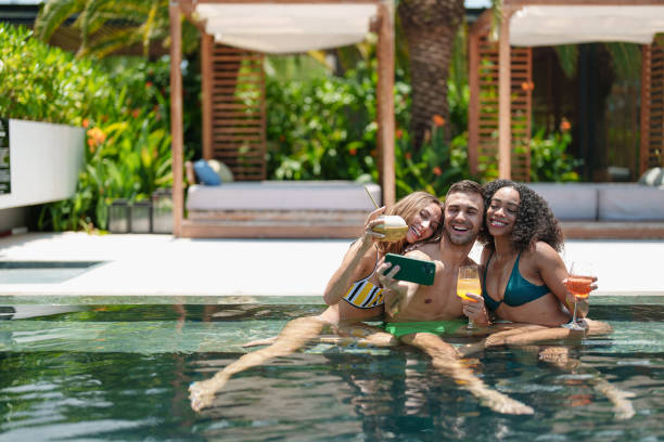 istock Smiling Friends Sharing Selfie Moment in Pool with Drinks 2187345744