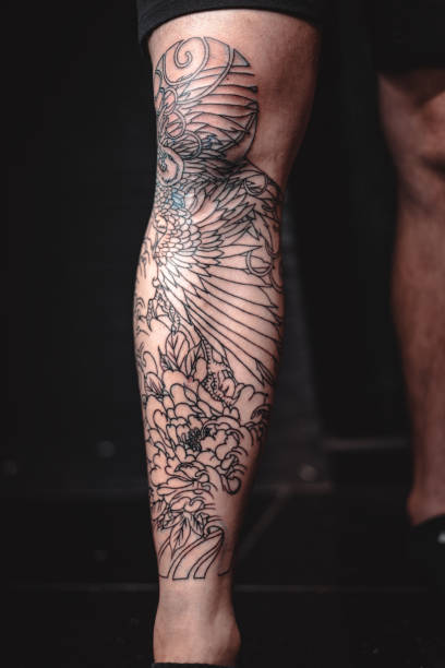istock Man with cool tattoos on black background, closeup. Leg 2187347550