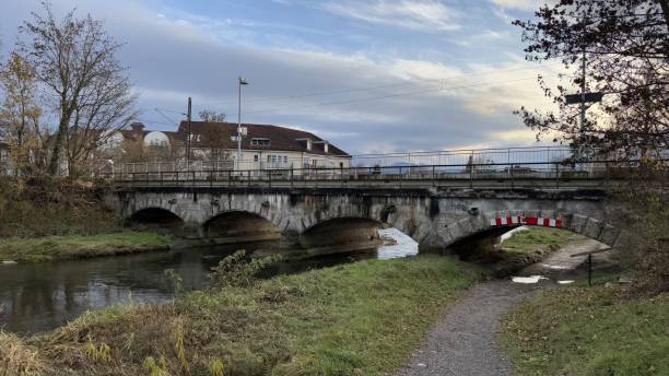 istock Stone Bridge Over Calm River Mangfall With Idyllic Countryside Setting and Cloudy Sky 2187350422