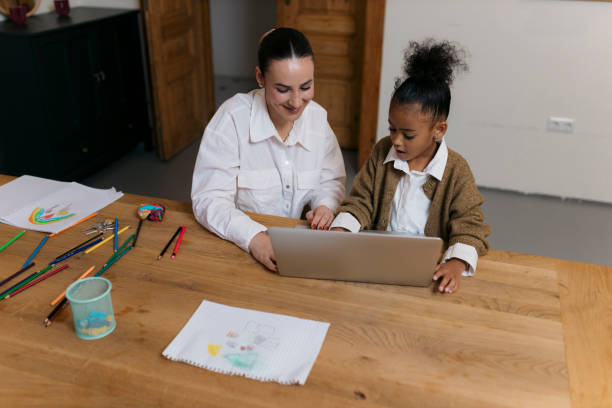 istock Young girl exploring laptop with mom's support at home 2187351822