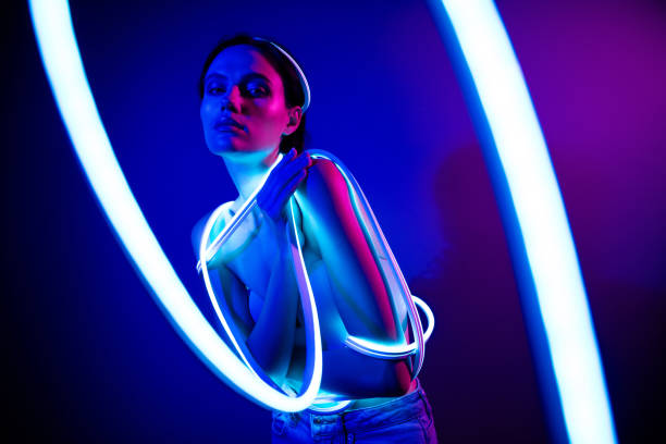istock Illuminated beauty with glowing neon lights in a dark blue studio background 2187352192