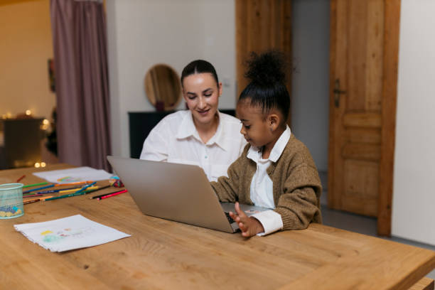 istock Mother and daughter learning together on laptop at table 2187353329