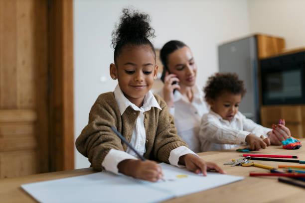 istock Child drawing at table as family spends time together 2187353499