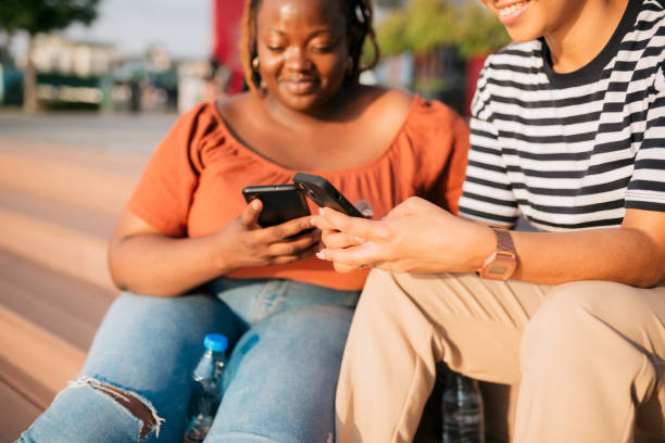 istock Friends sitting on city steps using mobile phones 2187355118