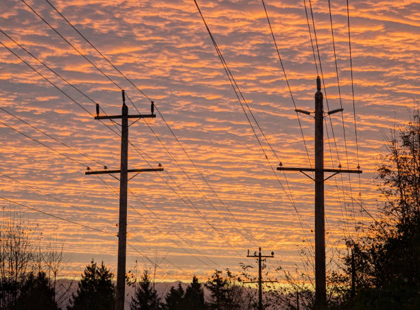 Sunrise at 7:00 a.m. in November with colorful clouds above the electrical grid on the Green Timbers Greenway in Surrey.