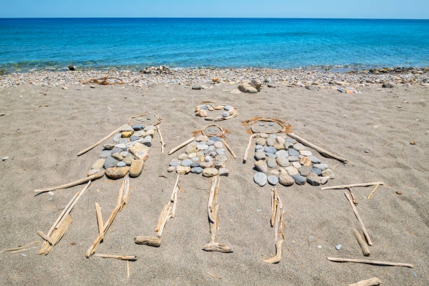 Happy family figures made by pebbles and driftwood on the sea shore