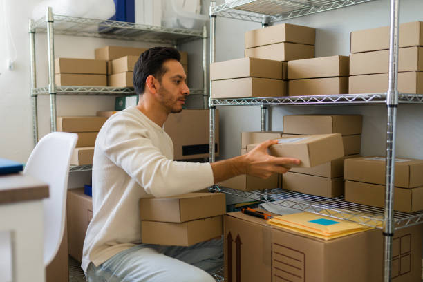 istock Small business owner preparing packages for shipment in a small warehouse, managing his online sales business 2187360573