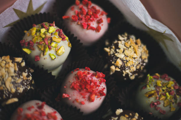 istock Various cake pops, pastries decorated with white and dark chocolate, nuts in a gift box 2187360678