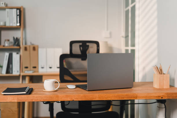 istock modern workspace featuring sleek laptop on wooden desk, complemented by coffee cup and stationery. organized setting promotes productivity and focus 2187363519
