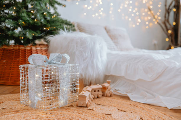 istock Cozy living room with Christmas tree and sparkling gift under soft lighting 2187368557