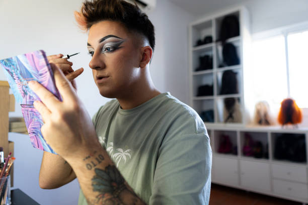 istock Drag queen applying eyeliner looking at the mirror in his dressing room 2187368734