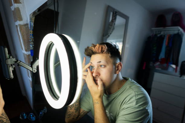istock Young man applying makeup and recording video with smartphone 2187368759