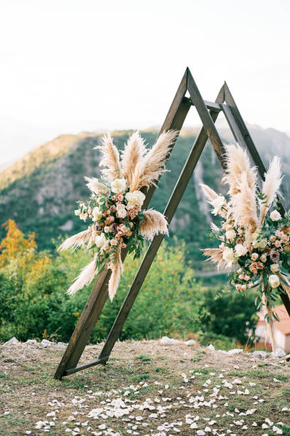 istock Triangular wedding tipi arch decorated with flowers stands on a mountain 2187369197