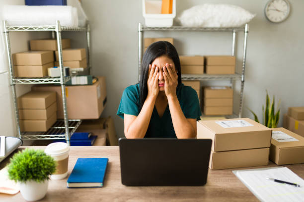 istock Stressed latin business owner hiding her face in her hands while managing challenges in her small office 2187370071