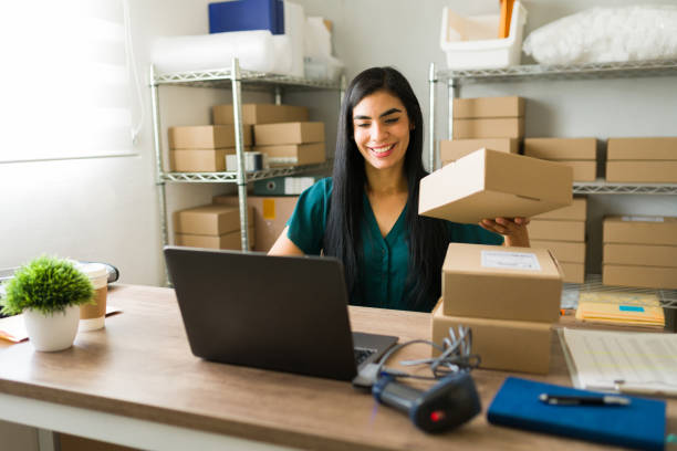 istock Cheerful latin entrepreneur multitasks happily in a busy warehouse, managing shipping and order fulfillment for her small e-commerce business 2187370167