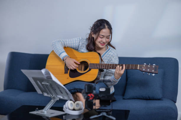 istock Woman Practicing Acoustic Guitar at Home 2187378883