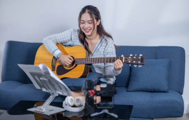 istock Woman Practicing Acoustic Guitar at Home 2187378956