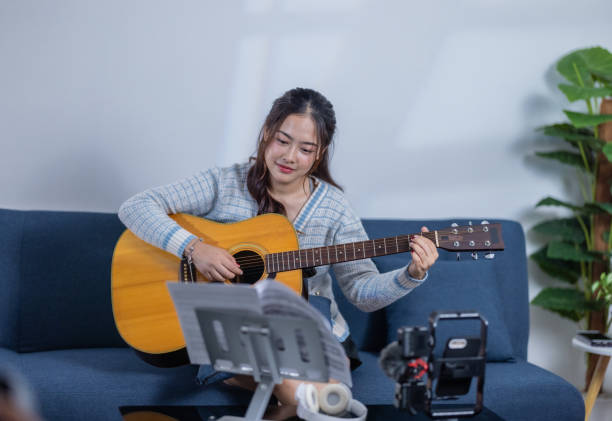 istock Woman Practicing Acoustic Guitar at Home 2187378958