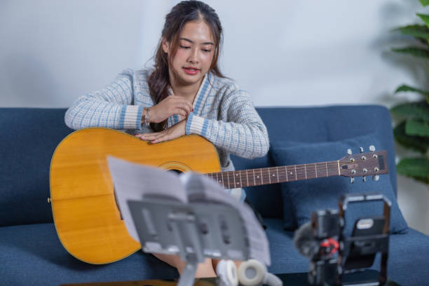 istock Woman Practicing Acoustic Guitar at Home 2187379333