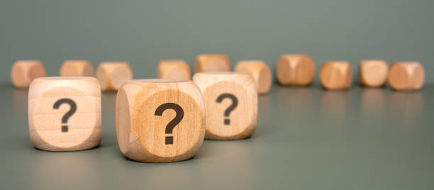 istock Intriguing Wooden Blocks That Are Beautifully Displaying Question Marks on a Gray Surface 2187379998