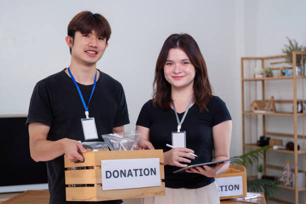 istock Happy Volunteers Smiling with Donation Box Indoors 2187380210