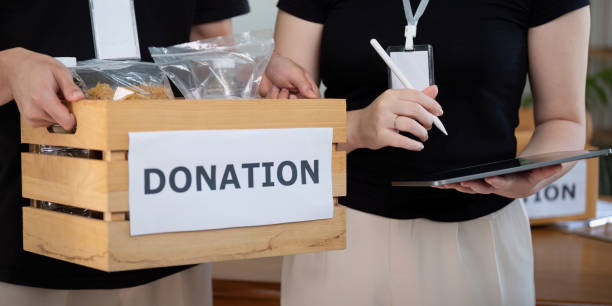 istock Volunteers Holding Box Recording Donations During Charity Event 2187380263