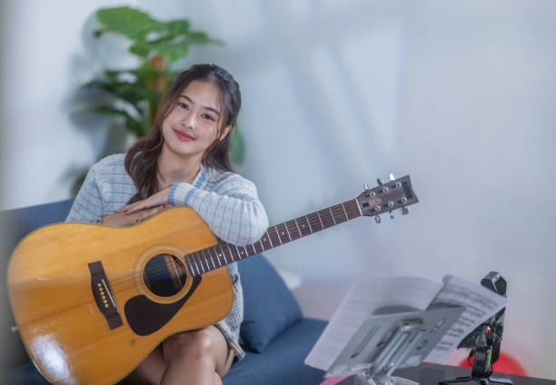 istock Woman Practicing Acoustic Guitar at Home 2187381220