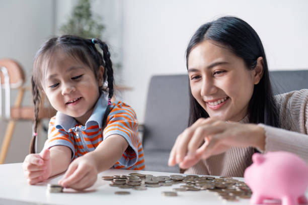 istock Happy Asian mother and daughter sorting coins together 2187381311