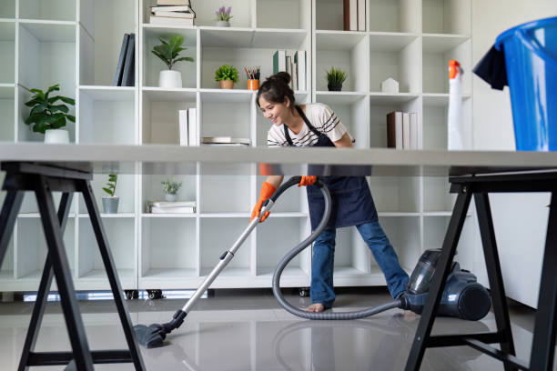 istock Woman vacuuming office floor with precision and focus 2187382084