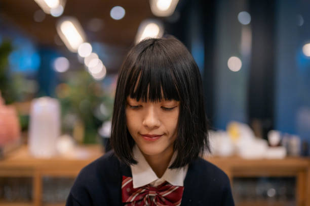 Woman in school uniform eating dinner in restaurant