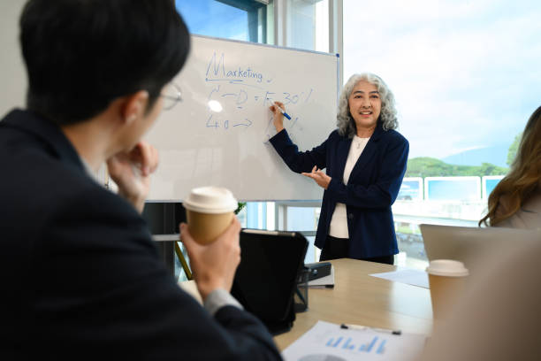 istock Confident senior female project manager explaining new corporate business plan at meeting 2187386700
