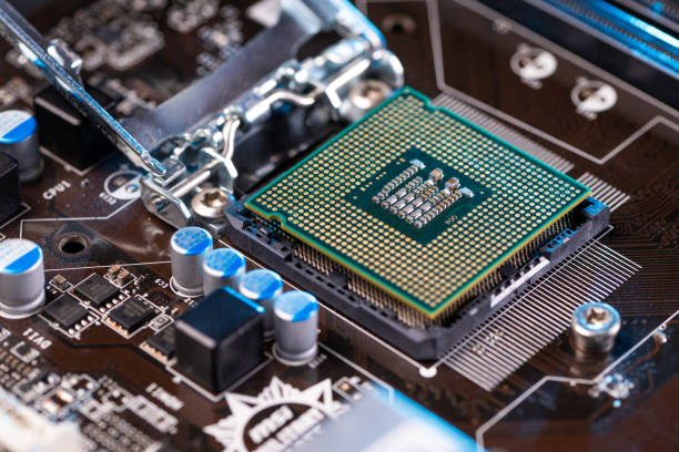 A detailed image of a CPU installed on a computer motherboard, surrounded by capacitors and circuits.