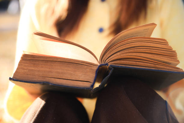 istock Young woman reading a book in autumn 2187389179