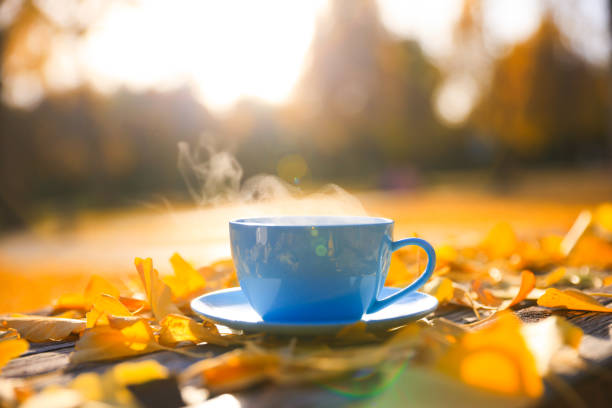 A hot cup of coffee on table in autumn