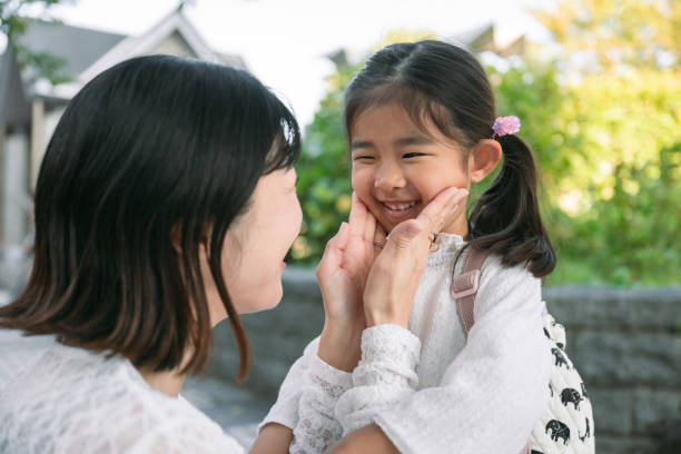 istock Japanese mother gently holding her daughter's cheeks in tokyo 2187392994