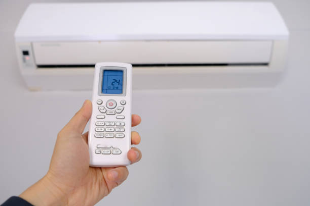 istock Man's hand using remote control open The air conditioner is cooled to 25 degrees Celsius in his bedroom. Health concepts and energy savings 2187393186