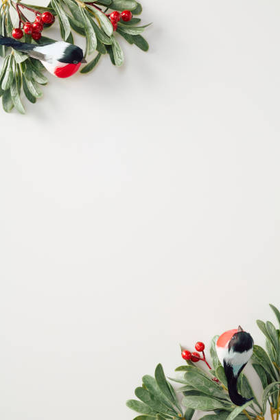 Festive holiday-themed border with vibrant greenery, red berries, and birds