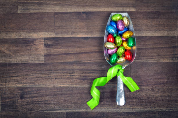 a vintage shovel with yummy chocolate easter eggs on wooden table, sweets for easter