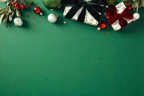 istock Modern Christmas gifts, baubles, festive decorations on green vertical background. Xmas frame. Flat lay, top view, copy space 2187396091