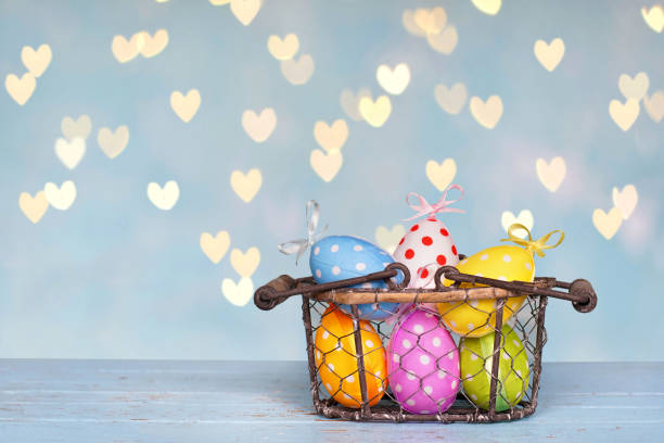 istock cute colorful easter eggs in a natural basket on rustic blue wooden board 2187396701