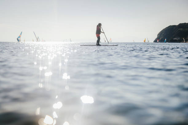 Asian woman in her 40's enjoying SUP in the sea.