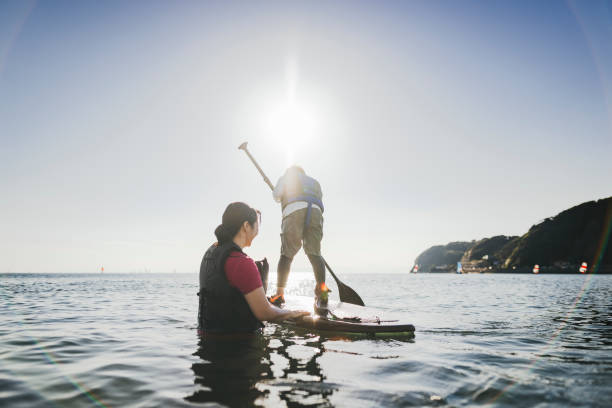 istock Mother and son playing stand up paddle boarding. 2187397409