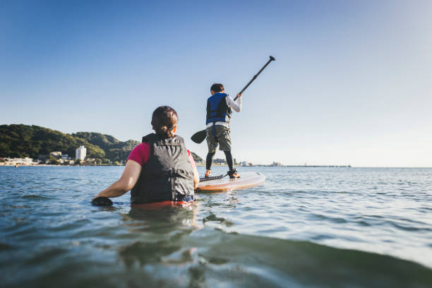 istock Mother and son playing stand up paddle boarding. 2187397411
