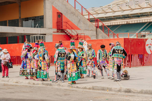 Moquegua, Peru - November 25, 2024 - Parade of traditional dances in southern Peru on a very hot day. Group of dancers in multicolored clothes, waiting for their turn.