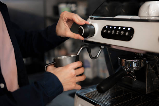 istock Barista Steaming Milk With a Coffee Machine Pitcher in a Modern Cafe 2187401678